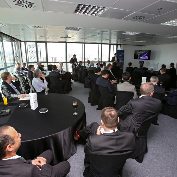 Speaker presenting during meeting natural light upper floor meeting room facing fira gran via