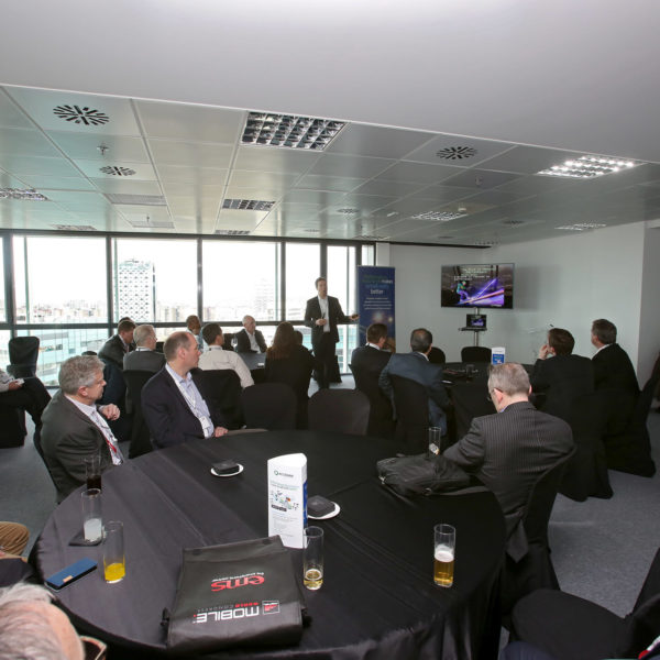 Speaker presenting during meeting natural light upper floor meeting room facing fira gran via