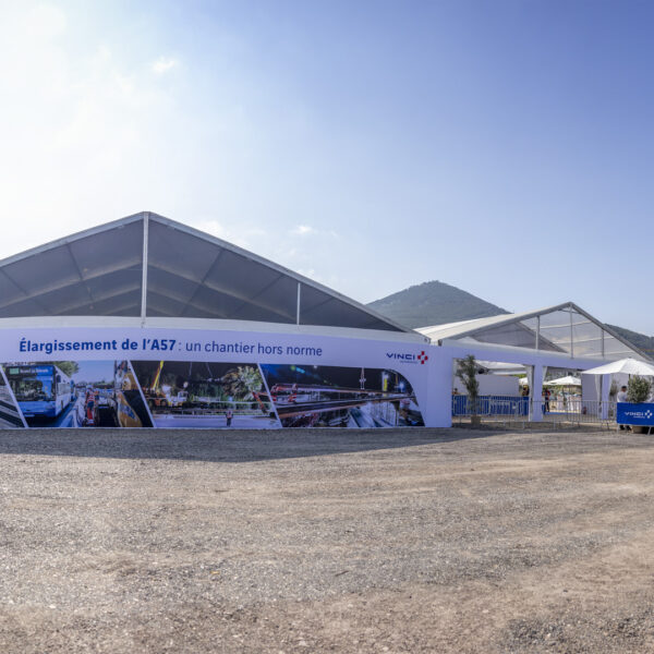 Two tents side by side with a gigantic printed visual and an entrance area