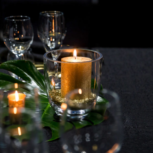 Golden candles on leaves center pieces with balck and gold theme during an MWC exclusive dinner in Barcelona