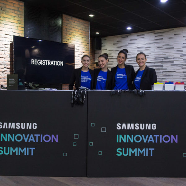 Hostesses behind the branded welcome desk ready to scan attendees at the innovation summit