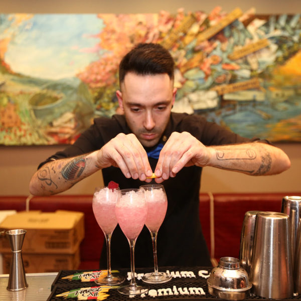 Bar tender preparing pink cocktails during pre-dinner drinks in Barcelona city center during MWC