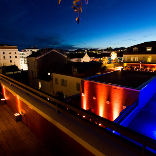 Rooftop terrace with a great view at dusk decorated with glowing globes and LEd lights on the walls during MIPIM