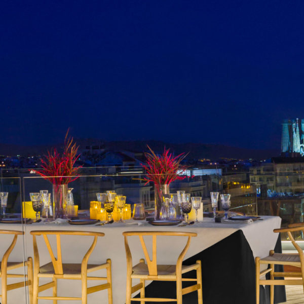 night view of the rooftop terrace with the Sagrada Familia lighted up in the brackground