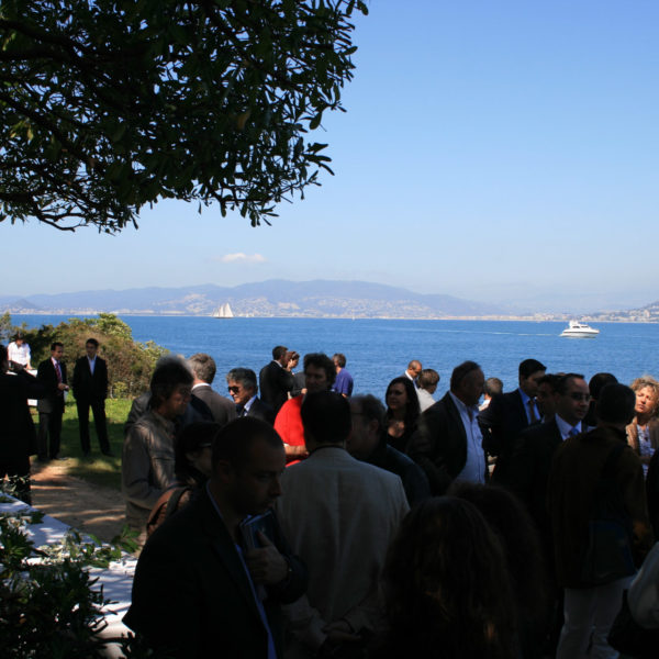Guests mingling and drinking the local wine on the side of the island facing Cannes