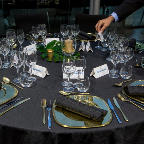Waiter putting the guests name tags on the tables for a strategic table plan