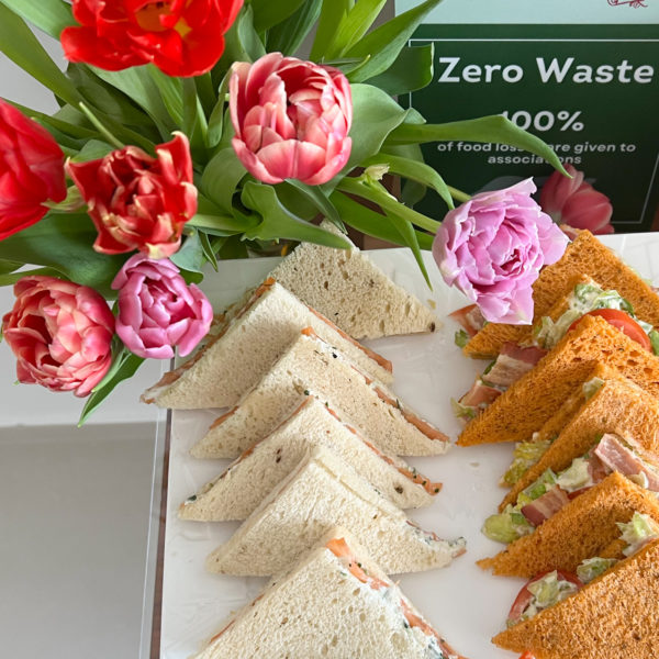 Sandwiches on plate, flowers and zero waste policy panel on buffet in the headquarters on the croisette