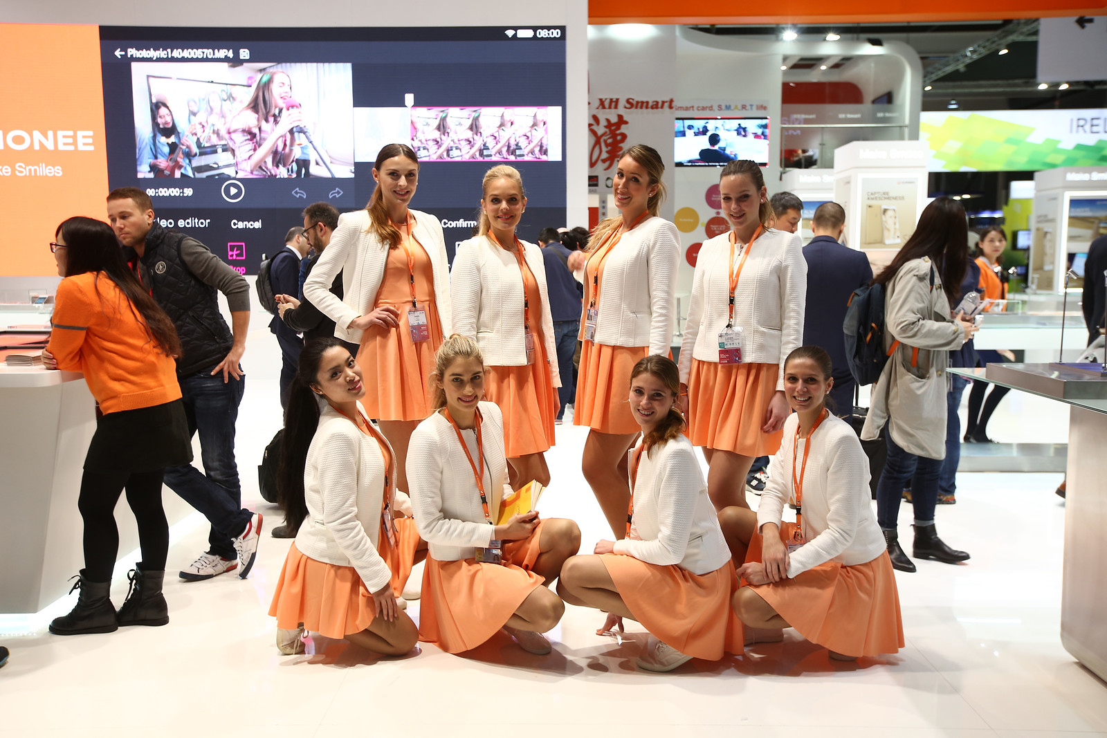 Hostesses at MWC booth during congress dressed with corporate colours