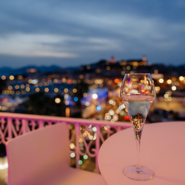 Glass of champagne with a view over Cannes at night from apartement during MIPIM