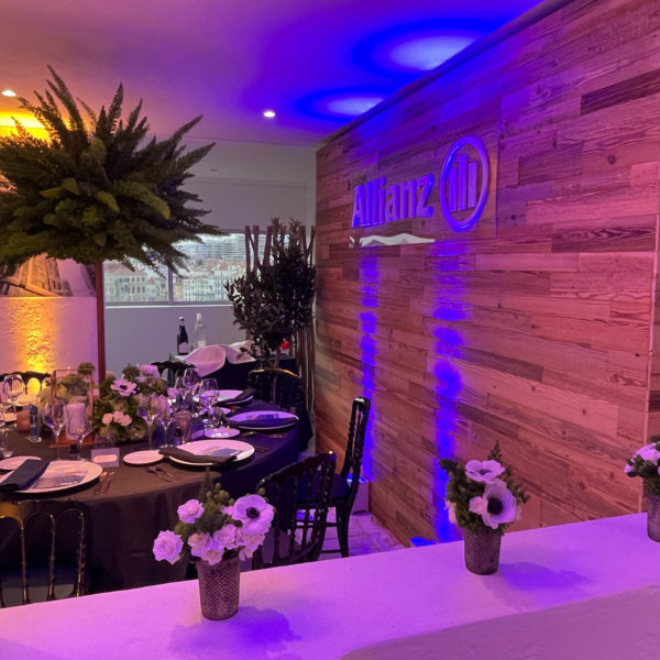MIPIM VIP dinner set-up with flowers and center pieces blue lighting over tailor made wooden wall
