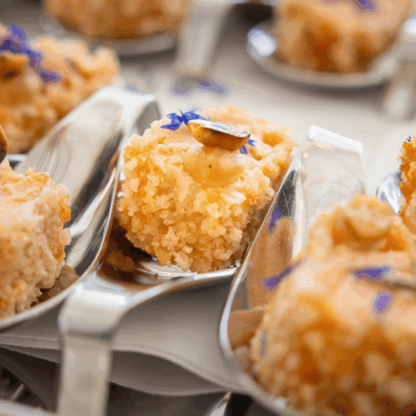Fried salmon pieces in spoon during networking event on the croisette in famous palace Carlton