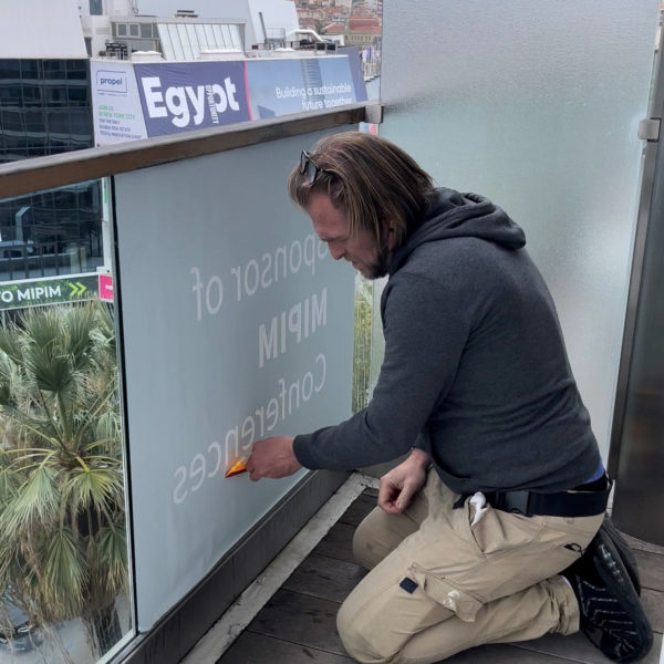 Stickers for branding being installed on glass barrier facing le palais des festivals during MIPIM