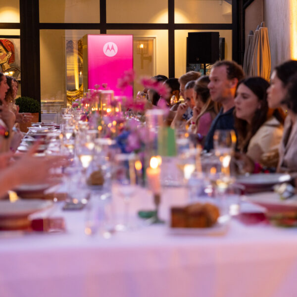 View of the table filled with guests and a lightbox in the background with vibrant pink customer colors