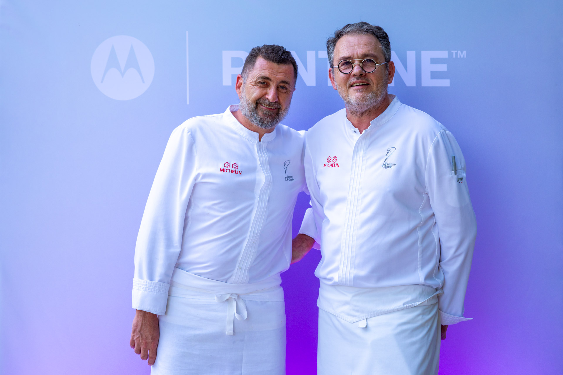 The two michelin star chef posing in front of the photocall with his team member