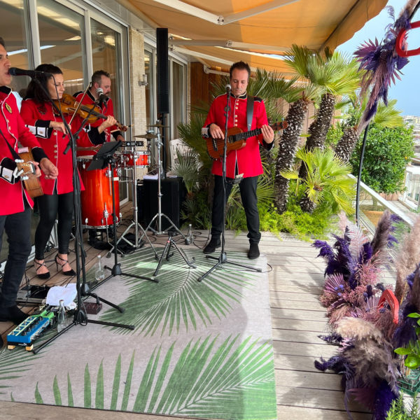 Band dressed up in red playing international hits during Cannes Lions on terrace facing the sea