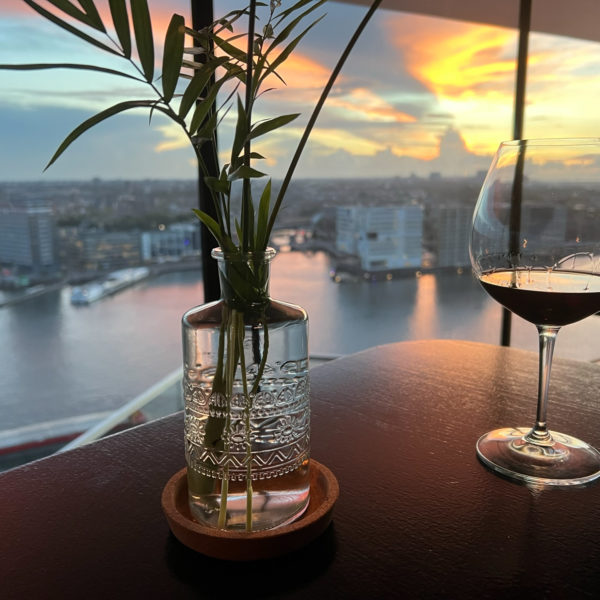 Glass of wine with a sunset over Amsterdam IBC 2022