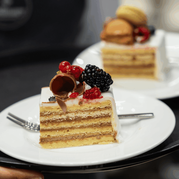Cake anniversary slice on plate served on trays by the waiters