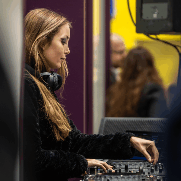 DJ woman while playing music during the Expo real networking event at the stand