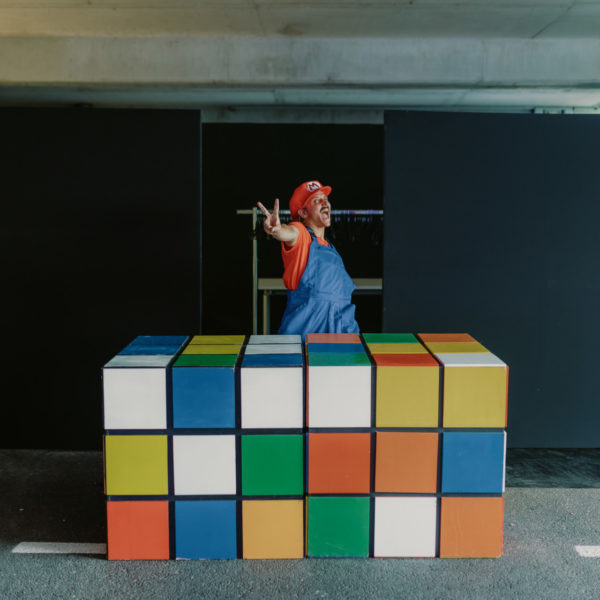 super mario performer in front of rubikub in front of the cloakroom