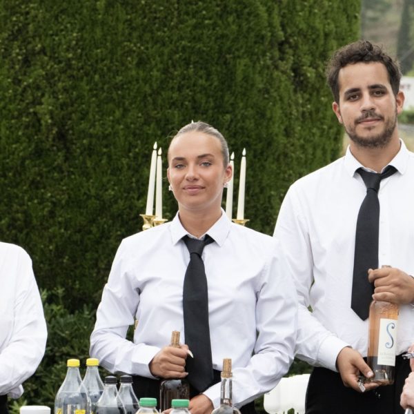 team of waiters posing elegantly behind the bars. Dress code: black and white with a tie, even for the ladies