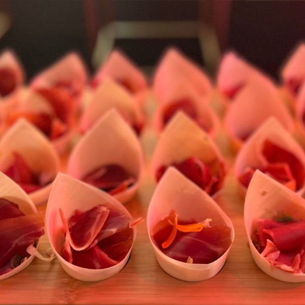 Cones of iberian ham presented on plate during the networking event at the end of the industry summit