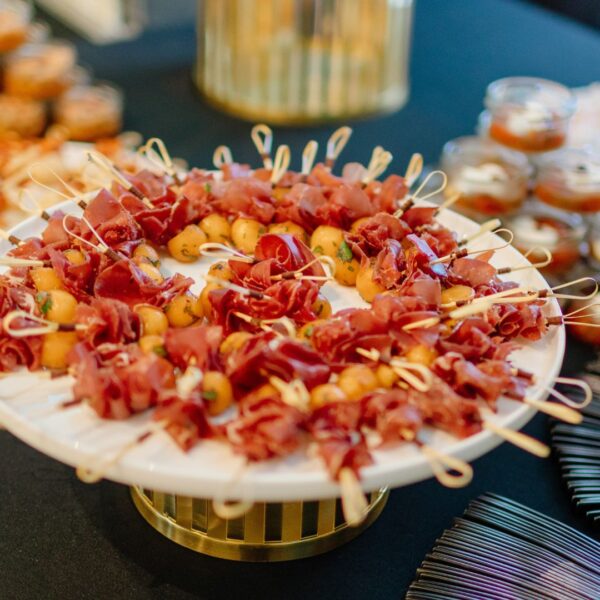 ham and melon skewers on a plate displayed on the buffet